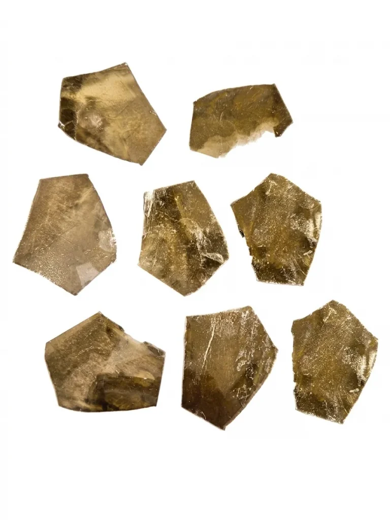Precision cut amber mica condenser films with irregular geometric shapes and a natural metallic luster.